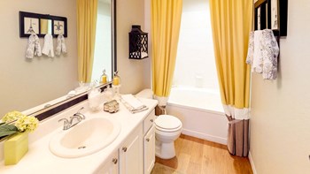 Private attached bathroom Master bathroom with white countertop and lower cabinets, large mirror, and combined tub and shower
